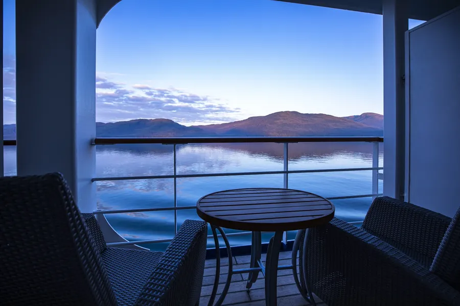 Balcony view of mountains and calm water near Juneau, Alaska, from the Regent Seven Seas Cruises 2028-2029 collection