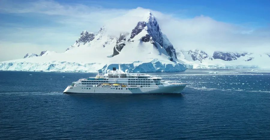Silversea ship Silver Endeavour below snow-covered peaks on the Antarctic coast